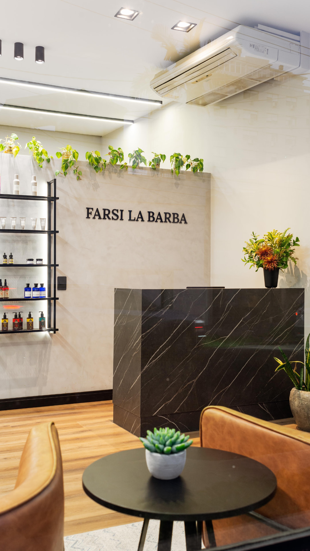 Recepção de barbearia com marcenaria, iluminação e paisagismo projetados pela Inova Arquitetura